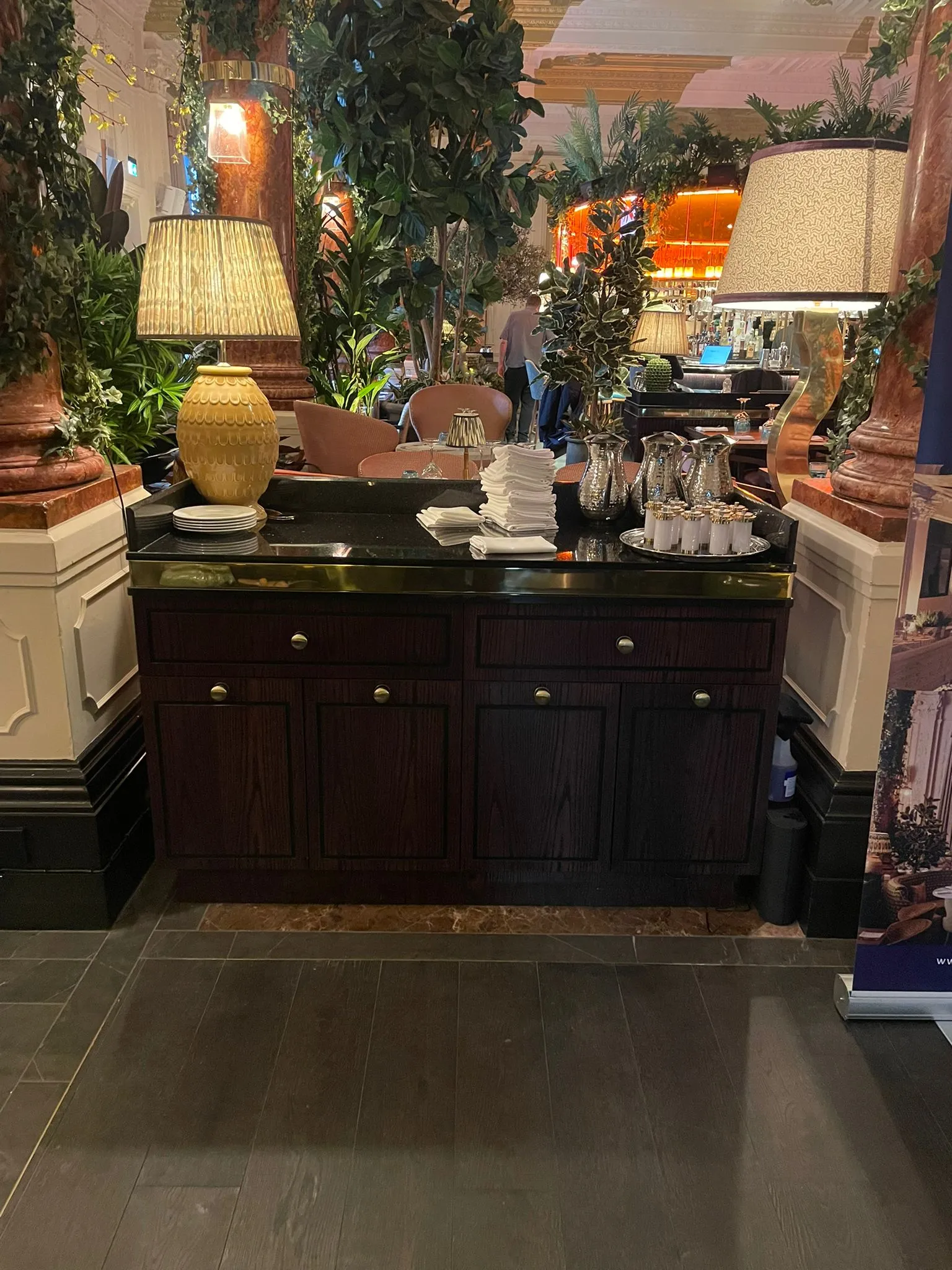 Dark timber waiter station set for service with a table lamp