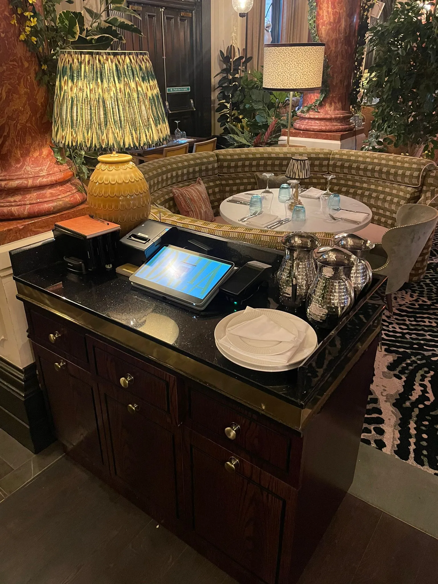 Waiter station beside a curved banquette in a restaurant