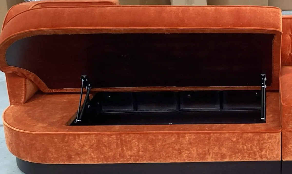 Velvet banquette seat with the lift-up storage lid open